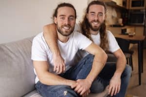 front view two brothers sitting on a couch. Image by freepik