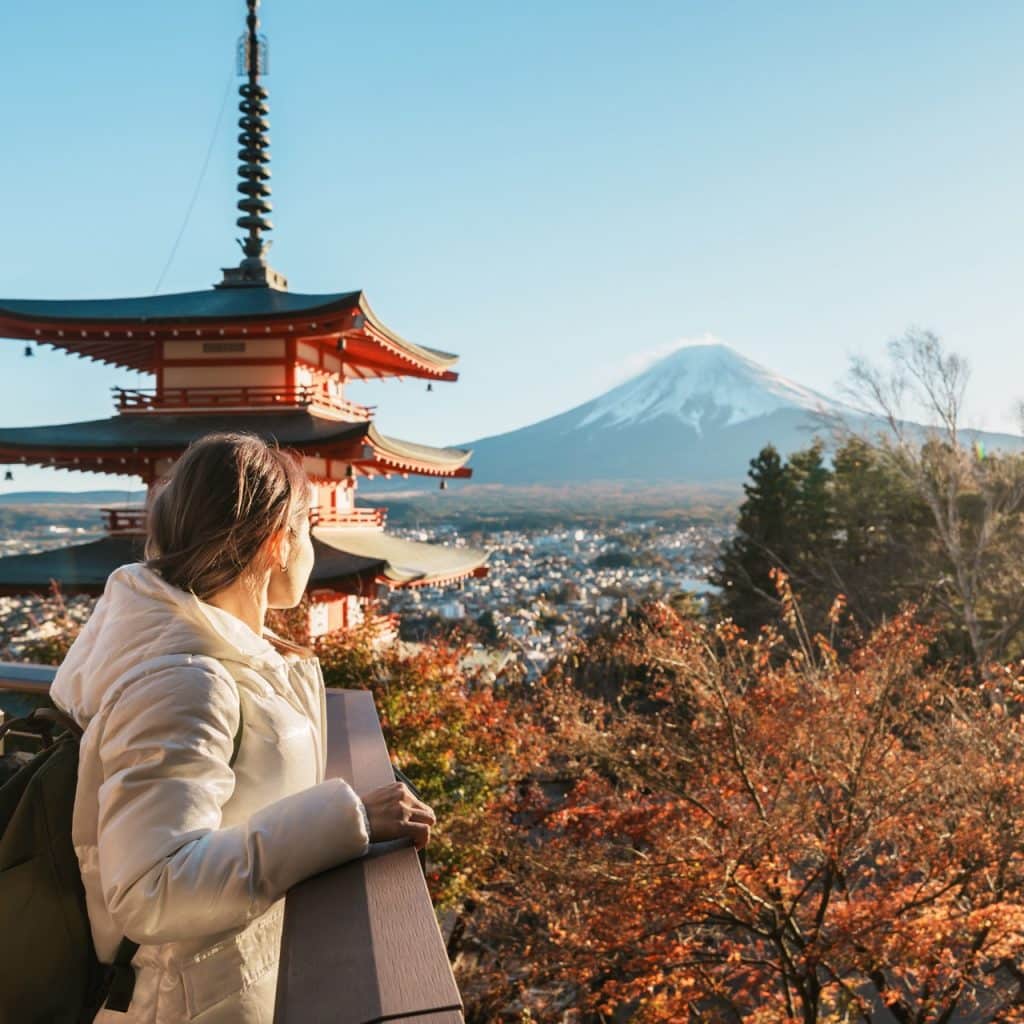 Woman tourist with mount Fuji at Chureito Pagoda in Autumn season.