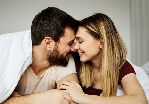 A happy man and woman leaning towards each other, their noses touching affectionately as they share a happy moment.